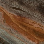 Vogue quartzite slab featuring dark brown and rust red layers, perfect for countertops in Highland Park. Vogue quartzite slab with dark brown and rust red layers from Highland Park.